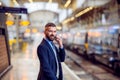 Hipster businessman with smartphone, making a phone call, platform Royalty Free Stock Photo