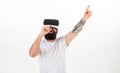 Hipster on busy face use modern technologies for entertainment or education. Man with beard in VR glasses, white