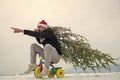 Hipster carrying xmas tree on white snow Royalty Free Stock Photo