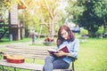 Hipster charming girl relaxing in the park while read book, Enjoy nature around Royalty Free Stock Photo