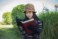 Hipster charming girl relaxing in the park while read book, Enjoy nature around Royalty Free Stock Photo