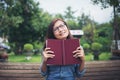 Hipster charming girl thinking something while reading red book Royalty Free Stock Photo