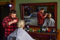 Hipster client getting haircut. Barber and client. Barber works hairstyle for bearded man barbershop background. Guy