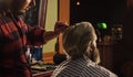 Hipster client getting haircut. Barber with scissors and client. Guy with long dyed blond hair close up. Do not cut your