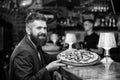 Hipster client sit at bar counter. Man received delicious pizza. Enjoy your meal. Cheat meal concept. Hipster hungry eat Royalty Free Stock Photo