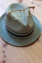 Hipster concept, fedora hat with horn rimmed vintage glasses perched on top, neutral wood background