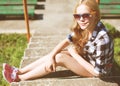 Hipster cool girl in sunglasses outdoors resting in the city