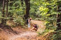 Hipster couple hiker stops to tie her shoe on summer hiking trail in forest. Man Tying Womans Shoes. Fun active