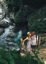 Hipster couple hiking on the background of a mountain river