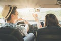 Hipster couple sitting in car and enjoying rod trip.