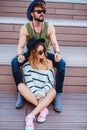 Hipster couple sitting on the stairs looking serious Royalty Free Stock Photo