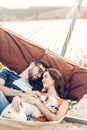 Hipster couple on a trip to the beach, young freelancer man relaxing in a hammock with his woman, romantic couple on vacation with Royalty Free Stock Photo