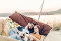 Hipster couple on a trip to the beach, young freelancer man relaxing in a hammock with his woman, romantic couple on vacation with Royalty Free Stock Photo