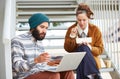 Hipster couple using computer and eating lunch outdoors Royalty Free Stock Photo