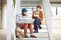 Hipster couple using computer and eating lunch outdoors Royalty Free Stock Photo