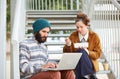 Hipster couple using computer and eating lunch outdoors Royalty Free Stock Photo