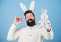 Hipster cute bunny blue background. Easter bunny. My precious. Funny bunny with beard and mustache hold pink egg. Easter