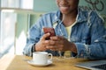 Hipster dark-skinned woman with Afro hairstyle talking on smart phone at cafe. Royalty Free Stock Photo