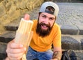 Hipster eat hot dog while sit on stairs outdoors. Urban food culture concept. Tasty hot dog sausage in roasty bun. Fast Royalty Free Stock Photo