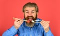 Hipster eat sushi with chopsticks. tasty sushi roll. traditional and healthy food in japan. japanese sushi dish. man Royalty Free Stock Photo