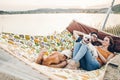 Hipster family on vacation concept, happy woman and man relaxing on a hammock at the beach with their cute bulldog pet, couple Royalty Free Stock Photo