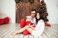 Hipster father and mother holding baby in santa suit