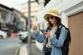 Hipster female traveler searching direction on smart phone. Life, people, travel and technology concept Royalty Free Stock Photo