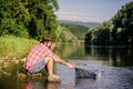 hipster fishing with spoon-bait. successful fisherman in lake water. fly fish hobby of man. Hipster in checkered shirt Royalty Free Stock Photo