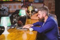 Hipster freelancer work online drinking coffee. Coffee break concept. Man bearded businessman sit bar counter with