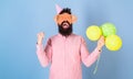 Hipster in giant eyeglasses celebrates birthday. Celebration concept. Man with beard on cheerful face hold air balloons