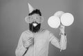 Hipster in giant sunglasses celebrating. Guy in party hat with air balloons celebrates. Man with beard on cheerful face Royalty Free Stock Photo