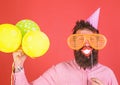 Hipster in giant sunglasses celebrating. Guy in party hat with air balloons celebrates. Photo booth fun concept. Man Royalty Free Stock Photo