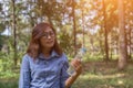 Beautiful asia women sitting drinking water in the forest.