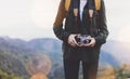 Hipster girl with backpack enjoying sunset on peak of foggy mountain, tourist traveler taking pictures of amazing landscape Royalty Free Stock Photo