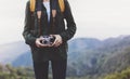 Hipster girl with backpack enjoying sunset on peak of foggy mountain, tourist traveler taking pictures of amazing landscape Royalty Free Stock Photo