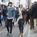 The hipster girl and boy dressed in cool Londoner style walking in Brick lane, a street popular among young trendy people Royalty Free Stock Photo