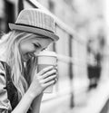 Hipster girl with cup of hot beverage on city street Royalty Free Stock Photo