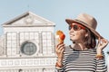 Girl eats popular Italian Gelato ice cream in the background of a tourist attraction