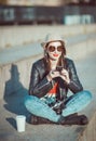 Hipster girl in leather jacket, hat with retro camera and mobile Royalty Free Stock Photo