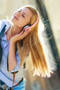 Hipster girl listening music on city street Royalty Free Stock Photo