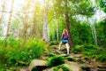 Hipster girl in the mountains. Stylish woman in straw hat and checkered shirt in forest. Wanderlust concept. Travelling and hiking