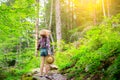 Hipster girl in the mountains. Stylish woman in straw hat and checkered shirt in forest. Wanderlust concept. Travelling in summer