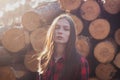 Hipster girl with a scared face on the background of felled trees