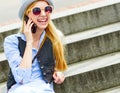 Hipster girl talking cell phone while sitting on stairs Royalty Free Stock Photo