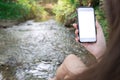 Hipster girl texting message on smartphone mobile with blank screen in forest nature, view tourist hands using gadget phone on ba Royalty Free Stock Photo