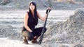 Hipster girl tomboy sits in a vacant lot with a baseball bat Royalty Free Stock Photo