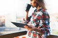 Hipster girl using tablet technology and drink coffee, girl person holding computer on background sun city, female hands texting m Royalty Free Stock Photo