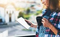 Hipster girl using tablet technology and drink coffee, girl person holding computer on background sun city, female hands texting