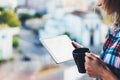 Hipster girl using tablet technology and drink coffee, girl person holding computer on background sun city, female hands texting m Royalty Free Stock Photo