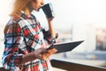 Hipster girl using tablet technology and drink coffee, girl person holding computer on background sun city, female hands texting m